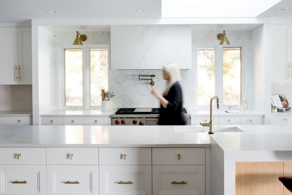 Idéer för stora funkis vitt kök och matrum, med en undermonterad diskho, luckor med infälld panel, vita skåp, bänkskiva i kvarts, vitt stänkskydd, stänkskydd i marmor, integrerade vitvaror, mörkt trägolv, en köksö och brunt golv