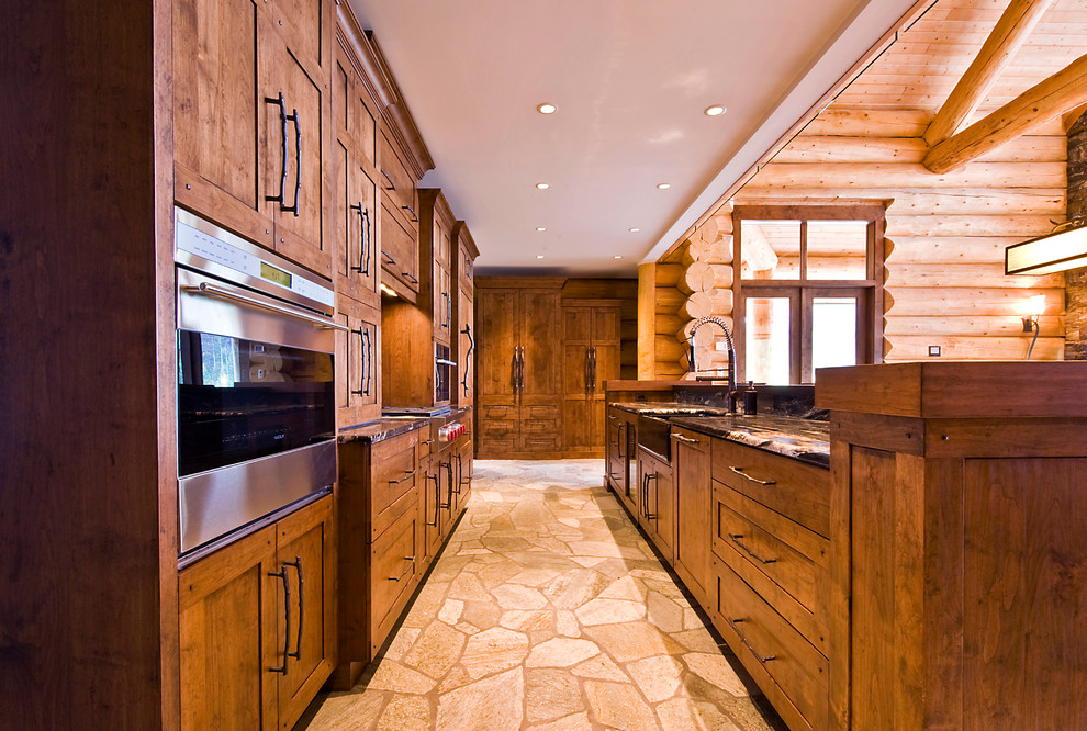 Idée de décoration pour une cuisine parallèle chalet en bois foncé avec un placard à porte shaker, un électroménager en acier inoxydable et un plan de travail en granite.