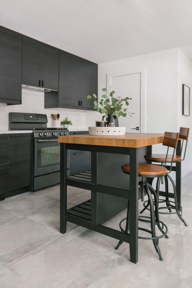 This is an example of a small scandi l-shaped kitchen pantry in Tampa with a built-in sink, flat-panel cabinets, black cabinets, engineered stone countertops, white splashback, engineered quartz splashback, black appliances, ceramic flooring, an island, grey floors and white worktops.