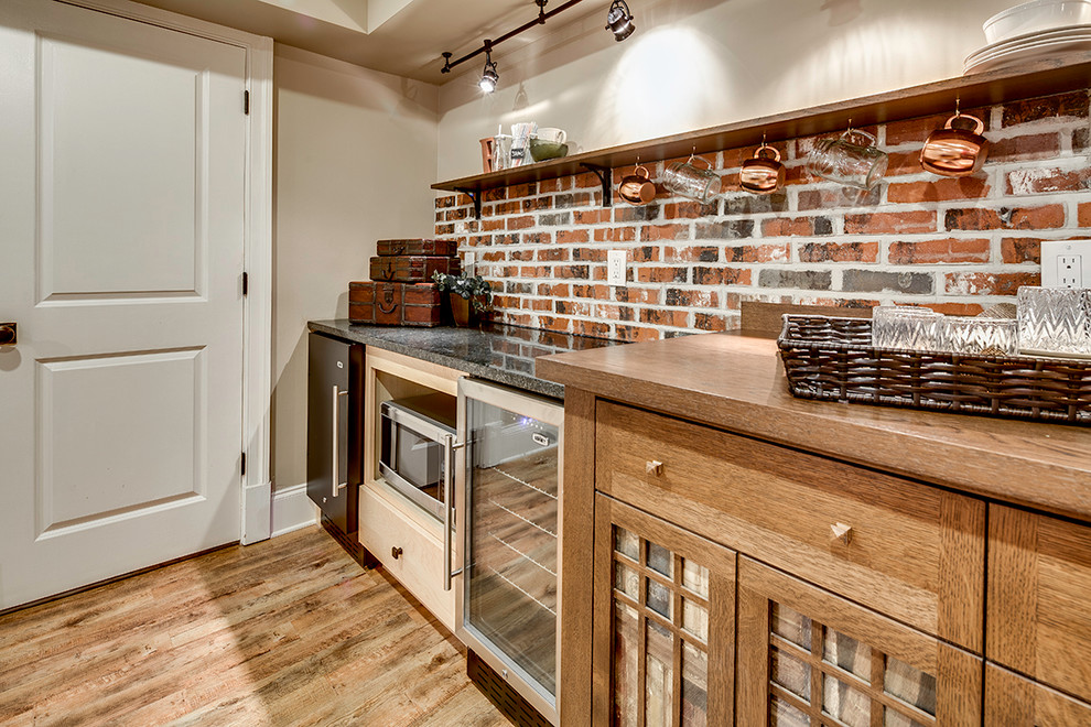 Diseño de cocinas en U rústico grande con puertas de armario marrones, encimera de granito, electrodomésticos de acero inoxidable y suelo de madera clara