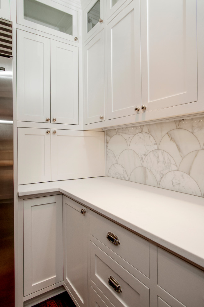 Exempel på ett avskilt, stort klassiskt vit vitt l-kök, med en undermonterad diskho, skåp i shakerstil, vita skåp, marmorbänkskiva, vitt stänkskydd, stänkskydd i marmor, rostfria vitvaror, mörkt trägolv, en köksö och brunt golv