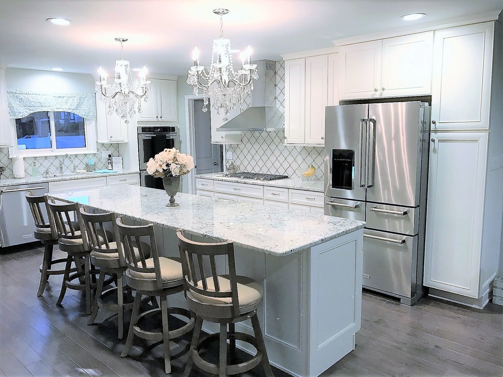 Idéer för ett mellanstort klassiskt grå kök, med en undermonterad diskho, skåp i shakerstil, vita skåp, granitbänkskiva, vitt stänkskydd, stänkskydd i porslinskakel, rostfria vitvaror, mellanmörkt trägolv, en köksö och grått golv