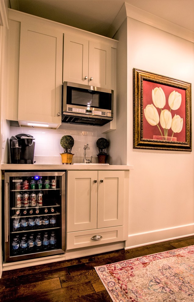 Exempel på ett litet klassiskt linjärt kök, med en undermonterad diskho, skåp i shakerstil, vita skåp, bänkskiva i betong, vitt stänkskydd, stänkskydd i keramik, rostfria vitvaror, mellanmörkt trägolv, en köksö och brunt golv