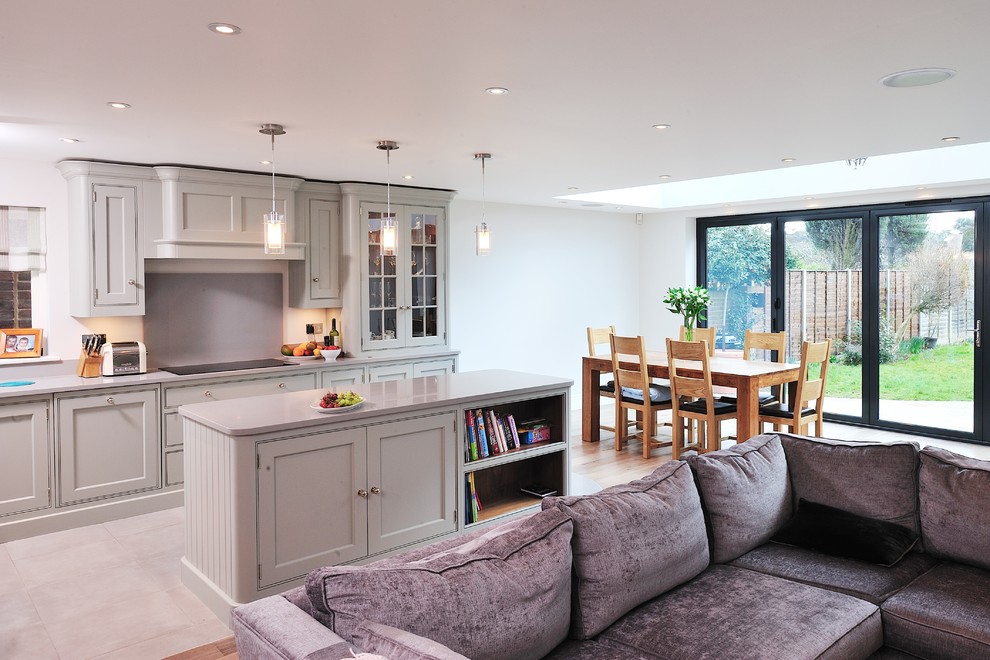 Photo of an open plan kitchen in Surrey with grey cabinets and an island.