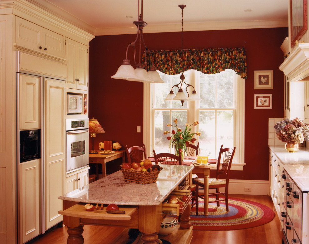 Foto di una cucina country chiusa con ante con riquadro incassato, ante beige, paraspruzzi bianco, elettrodomestici da incasso e top in granito