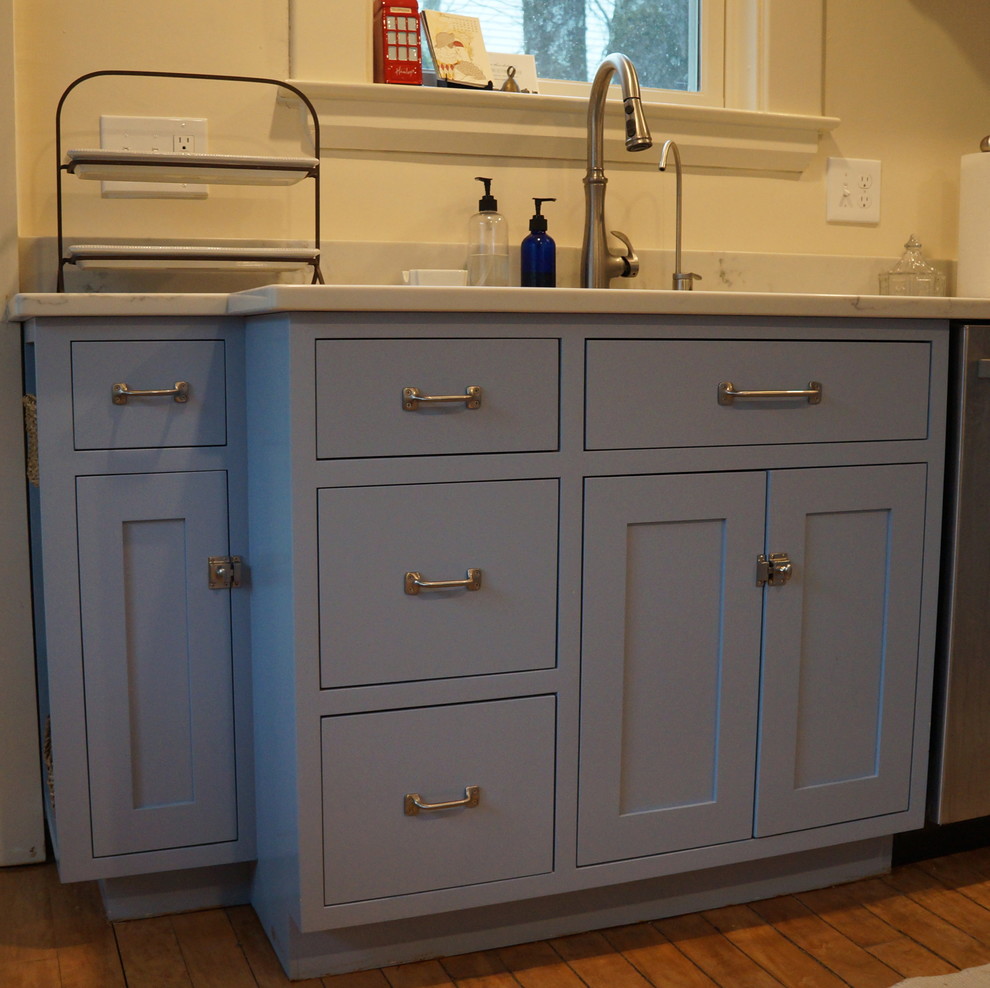 Exempel på ett litet klassiskt kök, med en enkel diskho, skåp i shakerstil, blå skåp, bänkskiva i kvarts, vitt stänkskydd, rostfria vitvaror, ljust trägolv och en köksö