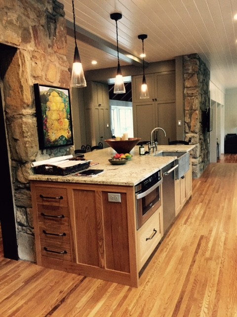 Foto på ett stort lantligt kök, med en rustik diskho, skåp i shakerstil, skåp i mellenmörkt trä, bänkskiva i kalksten, rostfria vitvaror, mellanmörkt trägolv och en köksö
