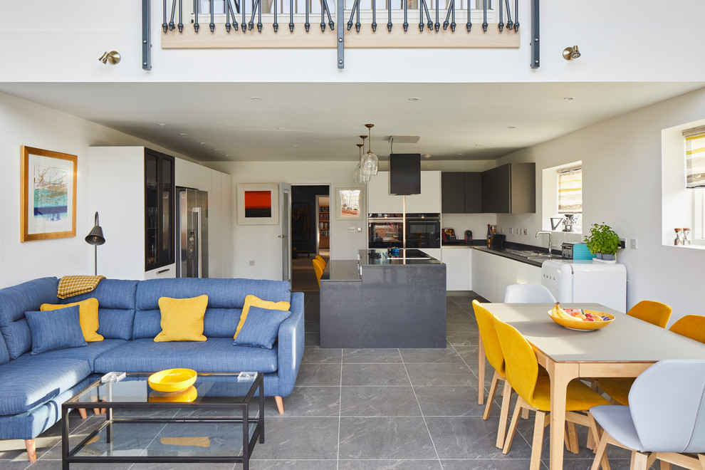 Scandinavian kitchen in Other with a double-bowl sink, flat-panel cabinets, white cabinets, grey splashback, slate flooring, grey floors, black appliances and black worktops.