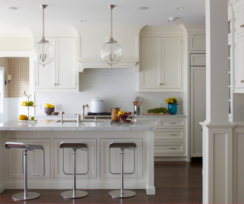 Beach style kitchen photo in New York with an undermount sink, recessed-panel cabinets, white cabinets, white backsplash and paneled appliances