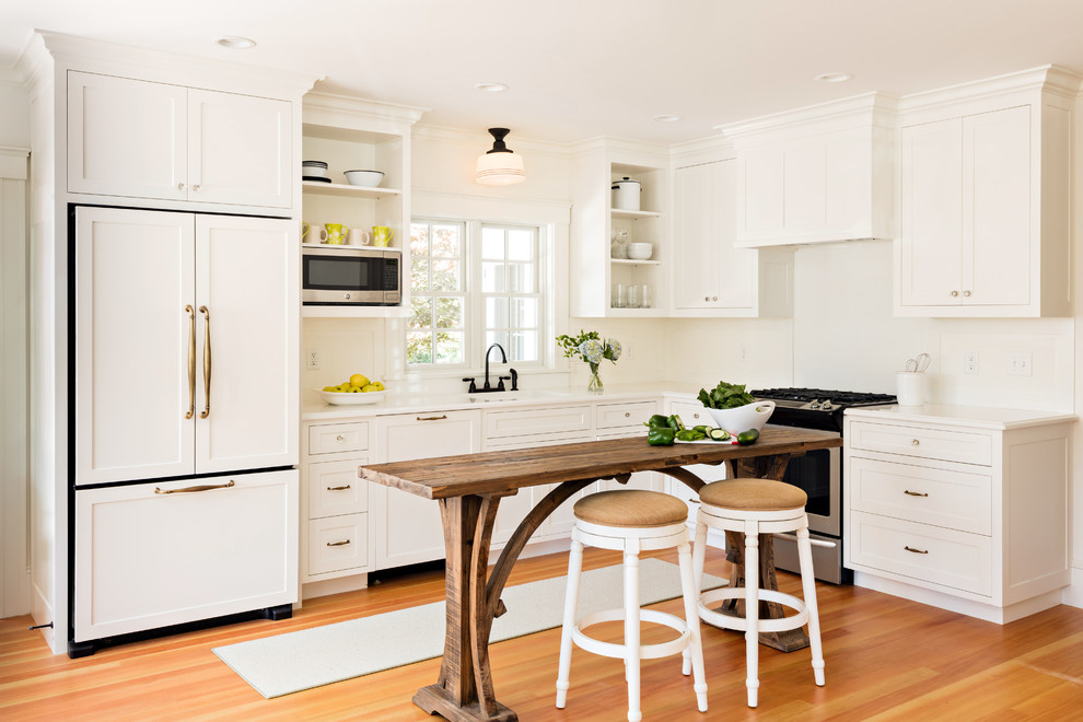 Inspiration for a farmhouse l-shaped medium tone wood floor kitchen remodel in Boston with shaker cabinets, white cabinets, white backsplash, stainless steel appliances and an island