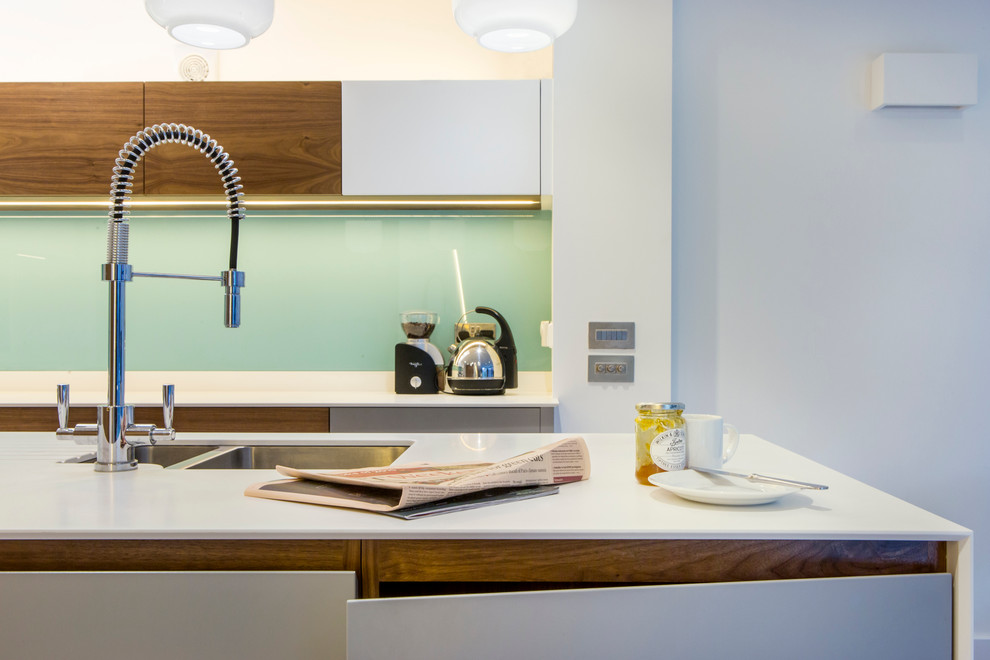 Foto de cocina actual de tamaño medio con fregadero bajoencimera, salpicadero azul, electrodomésticos de acero inoxidable y una isla