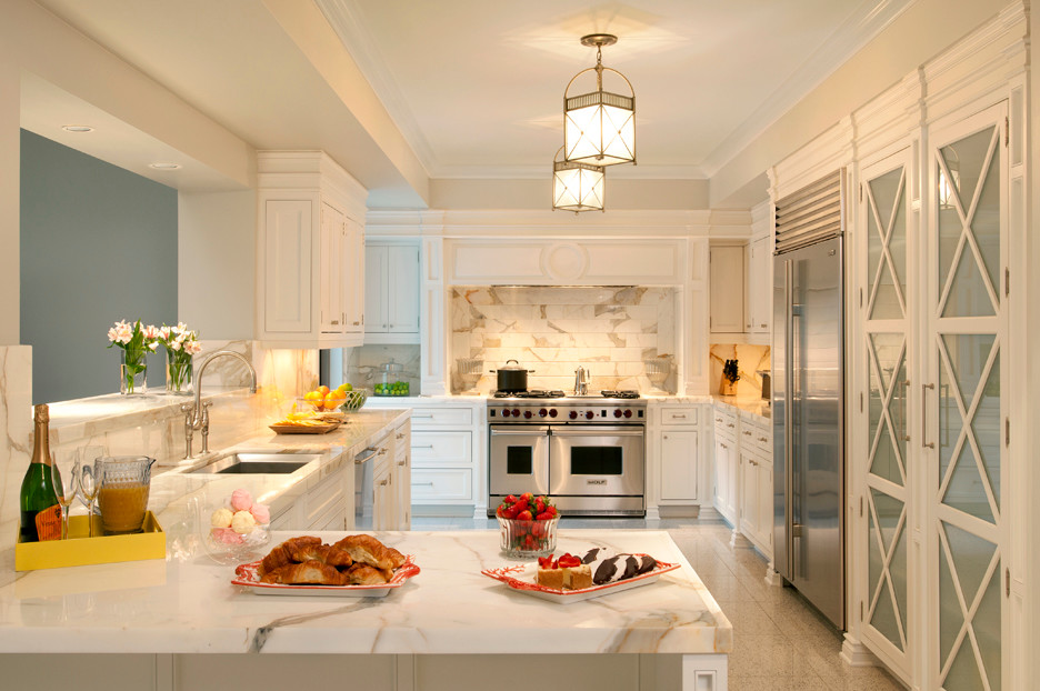 マイアミにあるトラディショナルスタイルのおしゃれなコの字型キッチン (シングルシンク、白いキャビネット、白いキッチンパネル、石タイルのキッチンパネル、シルバーの調理設備) の写真