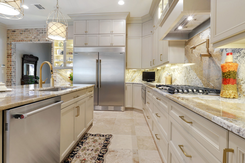 Klassisk inredning av ett stort kök, med en undermonterad diskho, luckor med infälld panel, beige skåp, granitbänkskiva, beige stänkskydd, stänkskydd i marmor, rostfria vitvaror, travertin golv, en köksö och beiget golv