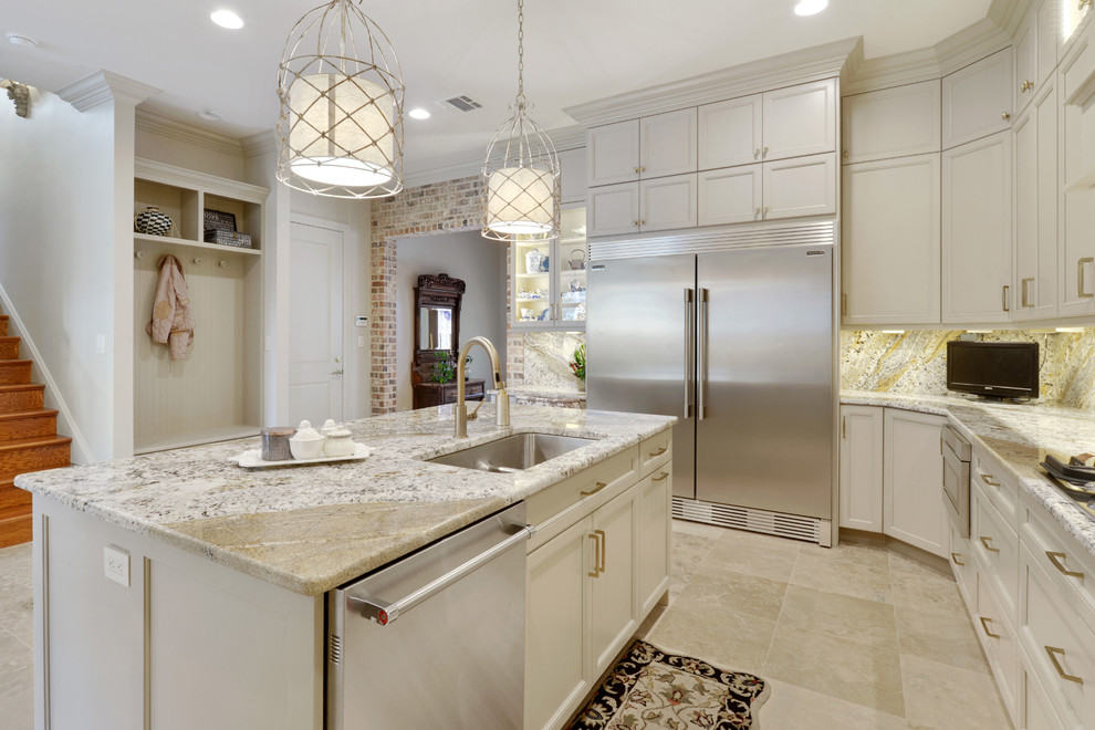Design ideas for a large classic u-shaped open plan kitchen in New Orleans with a submerged sink, recessed-panel cabinets, beige cabinets, granite worktops, beige splashback, marble splashback, stainless steel appliances, travertine flooring, an island and beige floors.