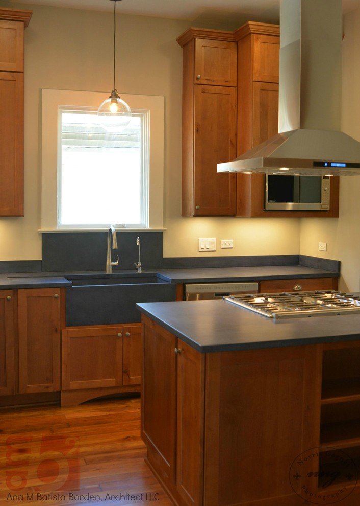 Foto på ett mellanstort rustikt kök, med en rustik diskho, luckor med infälld panel, skåp i mellenmörkt trä, bänkskiva i betong, blått stänkskydd, vita vitvaror, mellanmörkt trägolv och en köksö