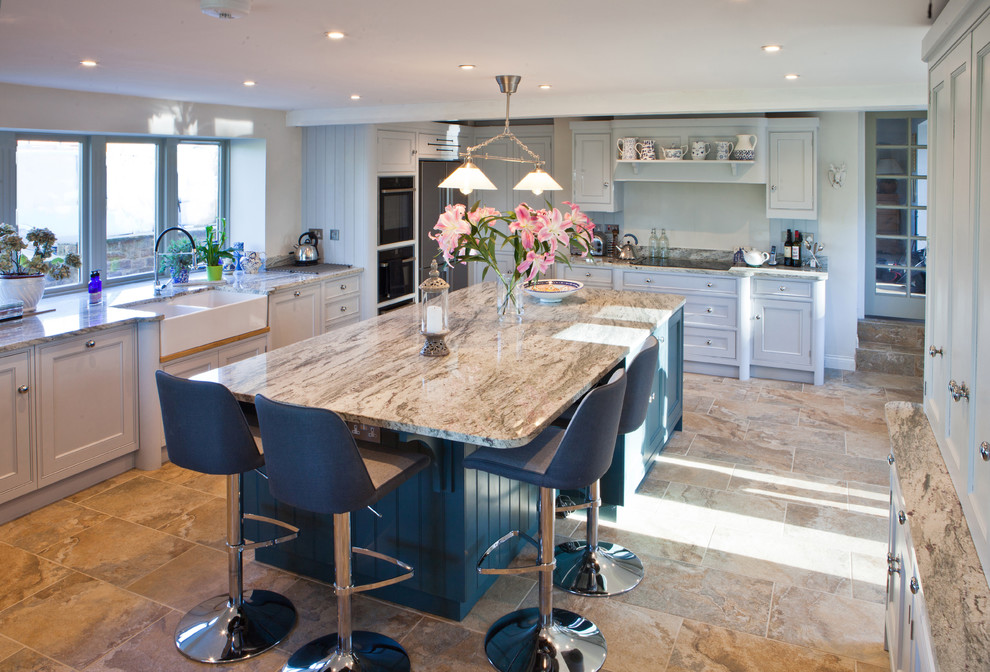 Example of a large classic l-shaped porcelain tile and beige floor eat-in kitchen design in Other with a farmhouse sink, shaker cabinets, blue cabinets, quartzite countertops, white backsplash, stone slab backsplash, stainless steel appliances and an island