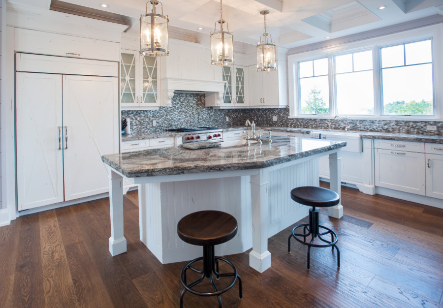 Exempel på ett mellanstort klassiskt kök, med skåp i shakerstil, vita skåp, rostfria vitvaror, en köksö, en rustik diskho, granitbänkskiva, brunt stänkskydd, stänkskydd i glaskakel, mellanmörkt trägolv och brunt golv