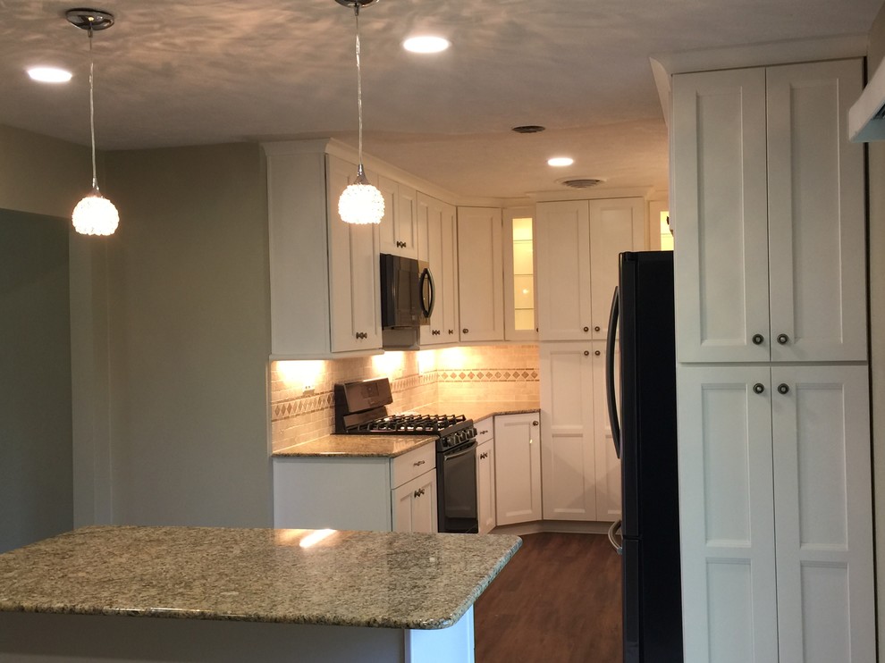 Photo of a small traditional u-shaped kitchen/diner in Houston with a submerged sink, shaker cabinets, white cabinets, granite worktops, beige splashback, stone tiled splashback, medium hardwood flooring and an island.