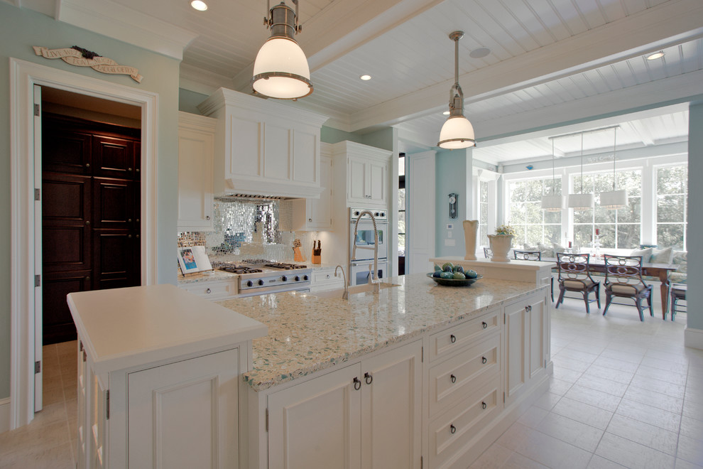 This is an example of a medium sized traditional single-wall kitchen/diner in Charleston with a belfast sink, recessed-panel cabinets, white cabinets, recycled glass countertops, stainless steel appliances, metallic splashback, mirror splashback and ceramic flooring.