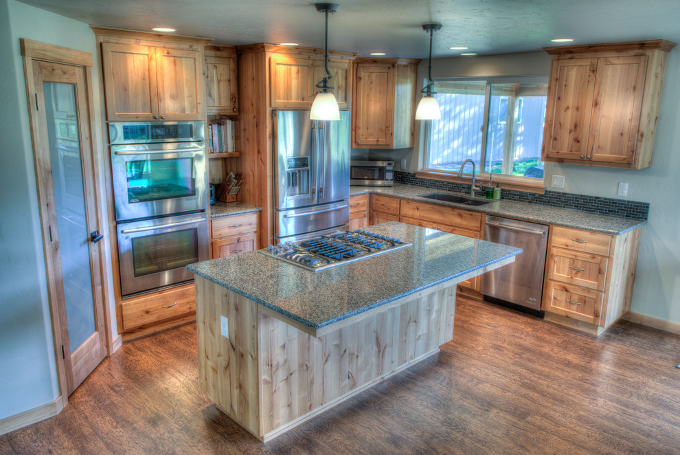 Exempel på ett mellanstort amerikanskt kök, med en undermonterad diskho, luckor med infälld panel, skåp i ljust trä, granitbänkskiva, flerfärgad stänkskydd, stänkskydd i porslinskakel, rostfria vitvaror, ljust trägolv och en köksö