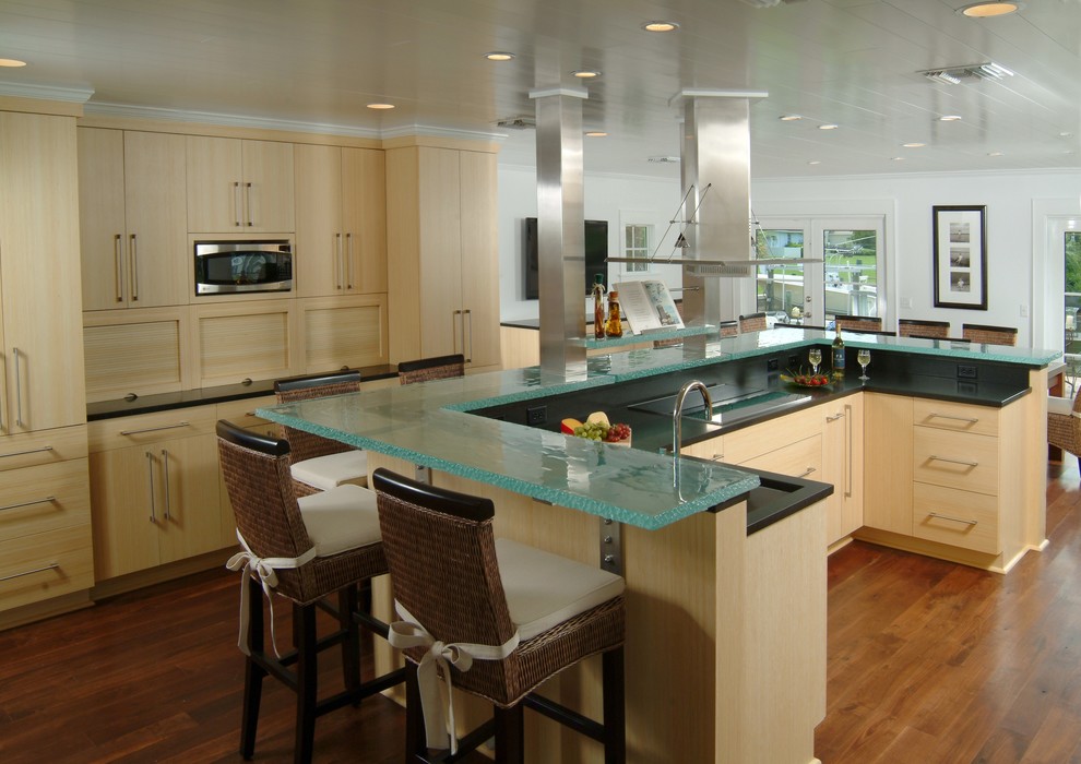Modelo de cocina actual con armarios con paneles lisos, electrodomésticos de acero inoxidable, encimera de vidrio y encimeras turquesas