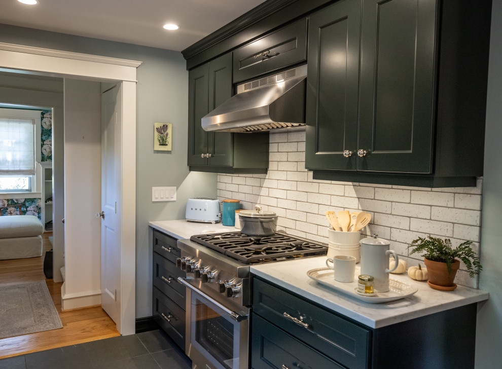 フィラデルフィアにある小さなトランジショナルスタイルのおしゃれなキッチン (エプロンフロントシンク、シェーカースタイル扉のキャビネット、緑のキャビネット、クオーツストーンカウンター、シルバーの調理設備、スレートの床、白いキッチンカウンター) の写真