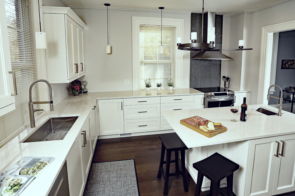 Klassisk inredning av ett mellanstort kök, med en undermonterad diskho, skåp i shakerstil, vita skåp, bänkskiva i kvarts, grönt stänkskydd, stänkskydd i skiffer, rostfria vitvaror, mellanmörkt trägolv, en köksö och brunt golv