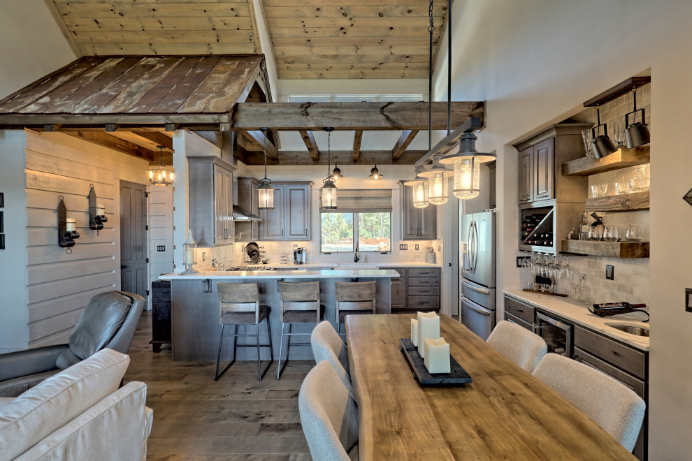 Inspiration for a small country u-shaped open plan kitchen in Atlanta with a belfast sink, raised-panel cabinets, light wood cabinets, engineered stone countertops, white splashback, travertine splashback, stainless steel appliances, a breakfast bar, brown floors and white worktops.