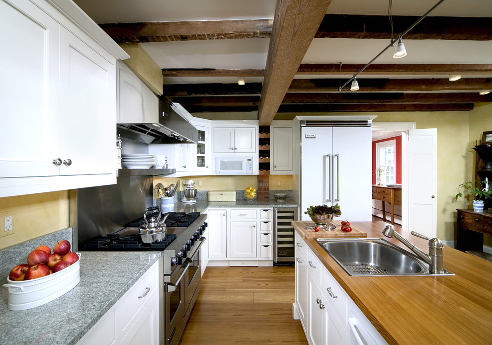 Diseño de cocina rústica de obra con electrodomésticos blancos, encimera de madera y fregadero encastrado