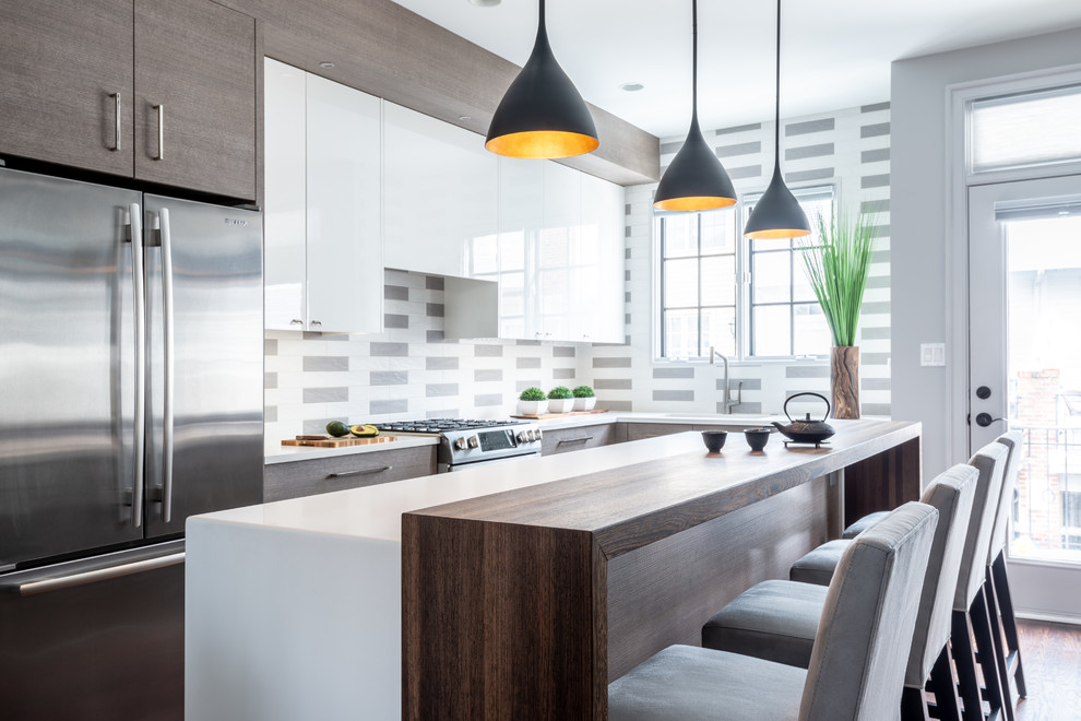 Trendy l-shaped dark wood floor and brown floor kitchen photo in DC Metro with an island, flat-panel cabinets, white cabinets, multicolored backsplash, stainless steel appliances and white countertops