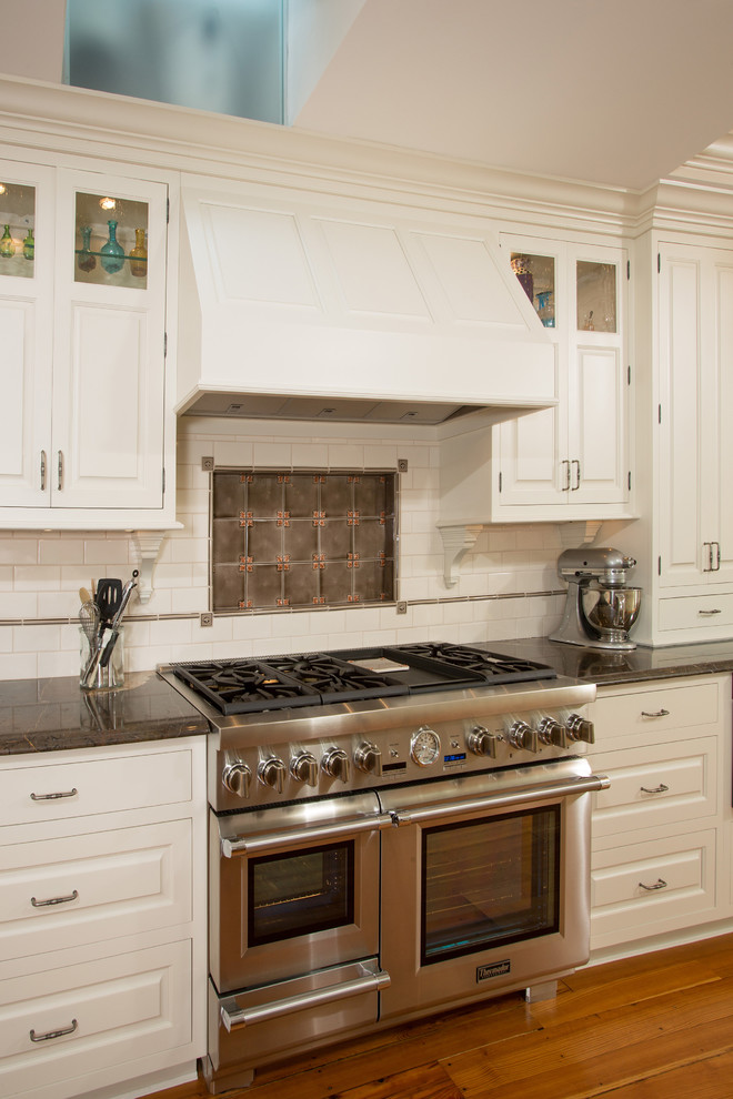 Idéer för att renovera ett avskilt, mellanstort vintage linjärt kök, med en undermonterad diskho, luckor med profilerade fronter, vita skåp, marmorbänkskiva, vitt stänkskydd, stänkskydd i keramik, rostfria vitvaror och mellanmörkt trägolv