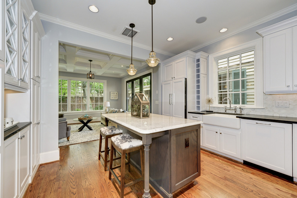Open concept kitchen - mid-sized transitional l-shaped medium tone wood floor open concept kitchen idea in DC Metro with a farmhouse sink, recessed-panel cabinets, white cabinets, quartz countertops, yellow backsplash, ceramic backsplash, paneled appliances and an island