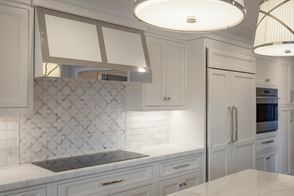 Inredning av ett klassiskt mellanstort kök, med luckor med upphöjd panel, vita skåp, marmorbänkskiva, vitt stänkskydd, stänkskydd i tunnelbanekakel, integrerade vitvaror och en köksö