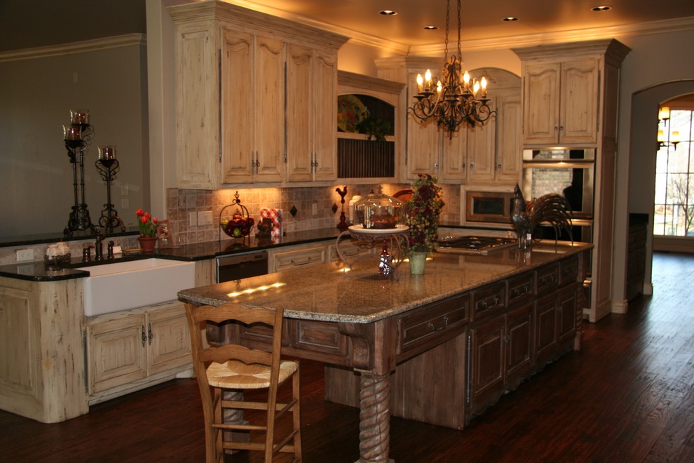 Exempel på ett mellanstort rustikt kök, med en rustik diskho, luckor med upphöjd panel, skåp i slitet trä, granitbänkskiva, beige stänkskydd, stänkskydd i stenkakel, rostfria vitvaror, mörkt trägolv och en köksö