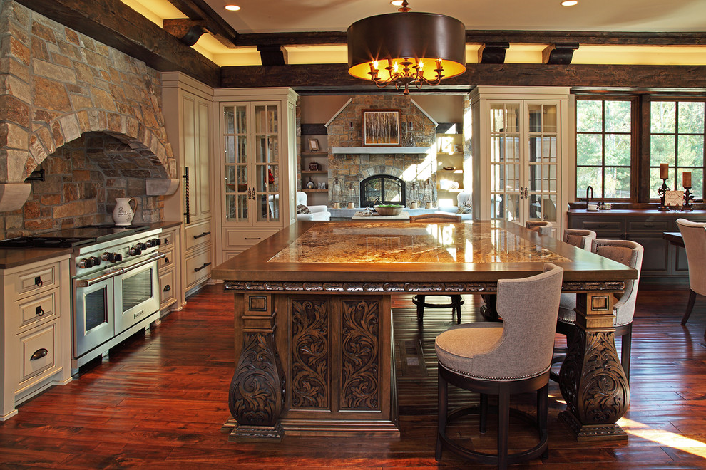 Bild på ett stort rustikt kök, med luckor med upphöjd panel, beige skåp, träbänkskiva, beige stänkskydd, stänkskydd i stenkakel, rostfria vitvaror, mörkt trägolv, en köksö och brunt golv