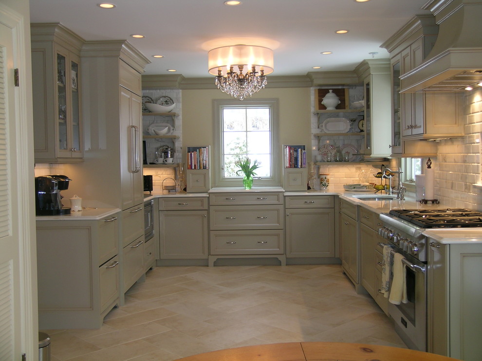 Enclosed kitchen - traditional travertine floor enclosed kitchen idea in Newark with paneled appliances, an undermount sink, recessed-panel cabinets, green cabinets, quartz countertops, white backsplash and stone tile backsplash