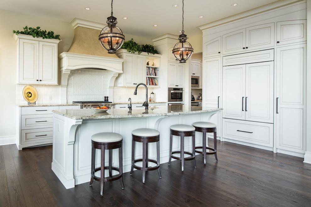 Example of a large classic l-shaped eat-in kitchen design in Vancouver with raised-panel cabinets, white cabinets, granite countertops, beige backsplash and an island