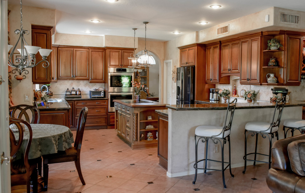 Exempel på ett mellanstort medelhavsstil kök och matrum, med granitbänkskiva, beige stänkskydd, rostfria vitvaror, en köksö och beiget golv