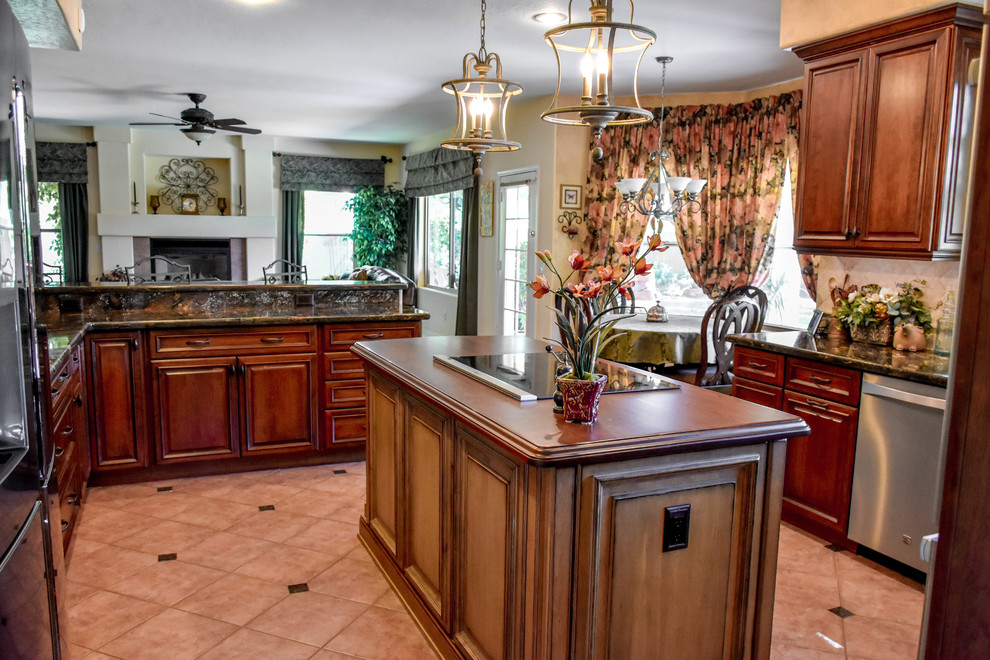 Foto på ett mellanstort medelhavsstil kök och matrum, med granitbänkskiva, beige stänkskydd, rostfria vitvaror, en köksö och beiget golv