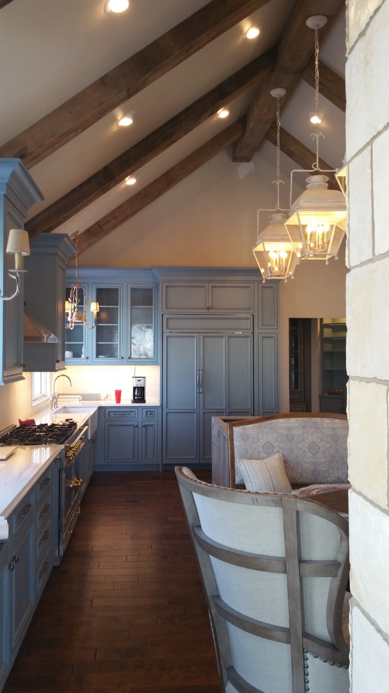 Shabby chic-inspirerad inredning av ett stort kök, med en rustik diskho, luckor med infälld panel, blå skåp, bänkskiva i kvartsit, flerfärgad stänkskydd, stänkskydd i porslinskakel, rostfria vitvaror, mellanmörkt trägolv och en köksö