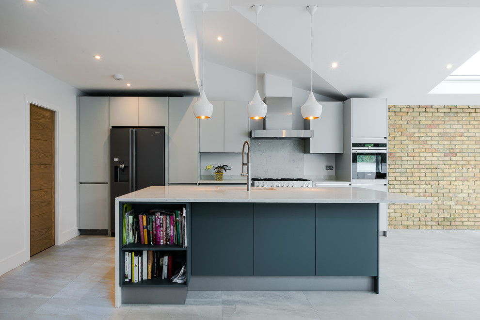 Example of a mid-sized minimalist single-wall gray floor kitchen design in London with an undermount sink, flat-panel cabinets, gray cabinets, gray backsplash, stainless steel appliances and an island