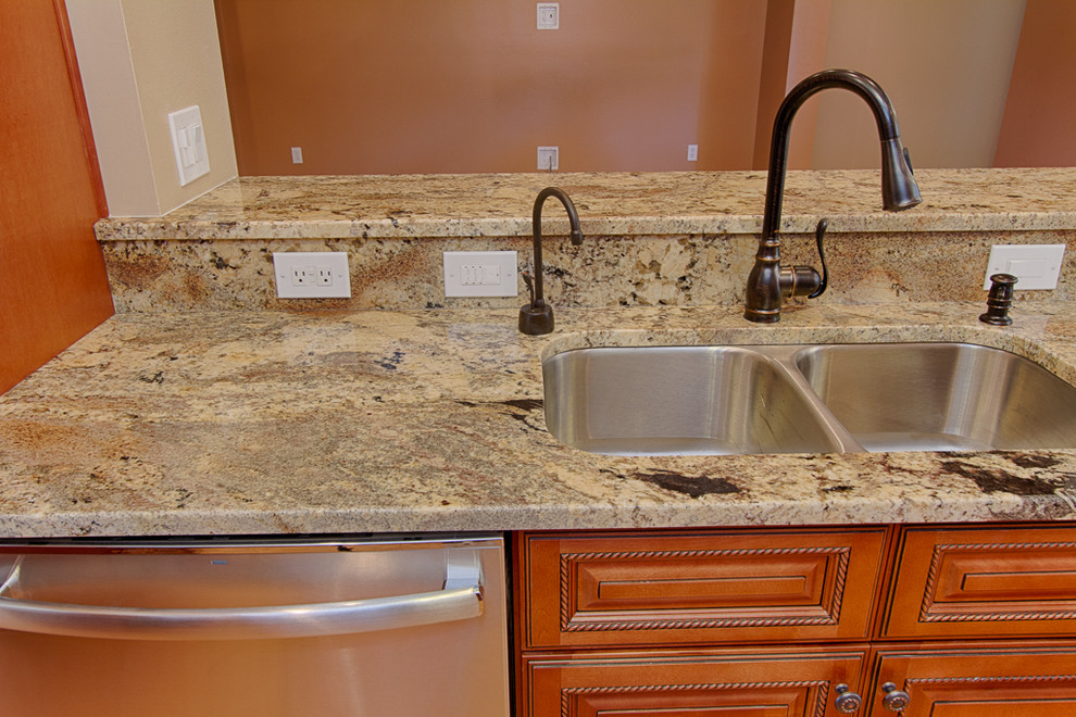 This is an example of a large classic galley kitchen/diner in Tampa with a submerged sink, beaded cabinets, medium wood cabinets, granite worktops, beige splashback, ceramic splashback, stainless steel appliances, medium hardwood flooring and an island.