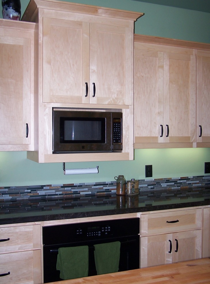 Example of a large arts and crafts u-shaped porcelain tile eat-in kitchen design in Other with a single-bowl sink, shaker cabinets, light wood cabinets, quartz countertops, multicolored backsplash, mosaic tile backsplash, black appliances and an island