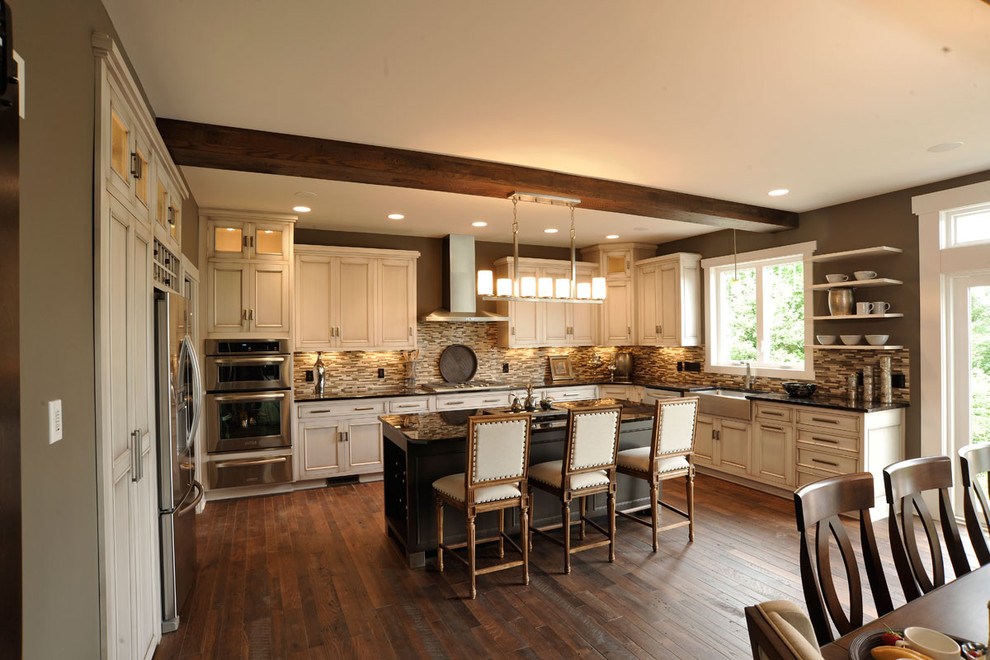 Bild på ett vintage flerfärgad flerfärgat kök, med en rustik diskho, luckor med profilerade fronter, skåp i slitet trä, brunt stänkskydd, stänkskydd i mosaik, rostfria vitvaror, mörkt trägolv och en köksö
