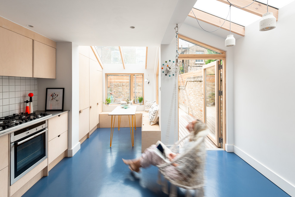 Источник вдохновения для домашнего уюта: кухня в скандинавском стиле с светлыми деревянными фасадами, столешницей из нержавеющей стали и синим полом