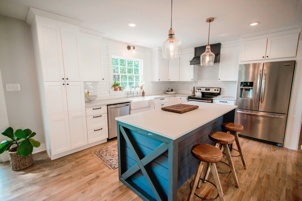 Exempel på ett lantligt grå grått kök, med en rustik diskho, skåp i shakerstil, vita skåp, bänkskiva i kvarts, vitt stänkskydd, stänkskydd i keramik, rostfria vitvaror, ljust trägolv, en köksö och beiget golv