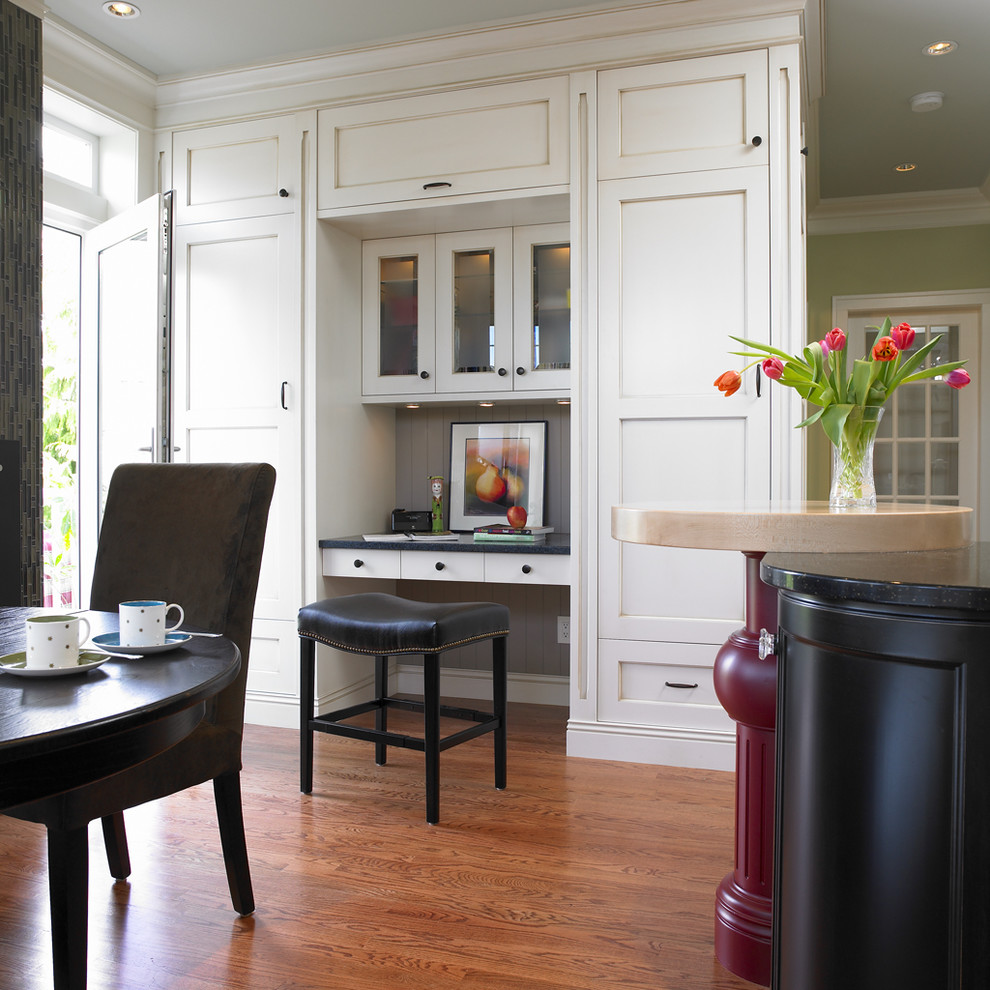 На фото: кухня в классическом стиле с обеденным столом, фасадами с утопленной филенкой, белыми фасадами и серым фартуком
