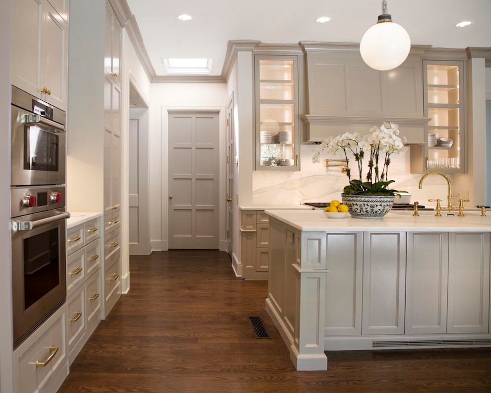 Inspiration for a huge transitional l-shaped dark wood floor kitchen remodel in Austin with recessed-panel cabinets, gray cabinets, marble countertops, white backsplash, marble backsplash, stainless steel appliances, an island, a farmhouse sink and white countertops