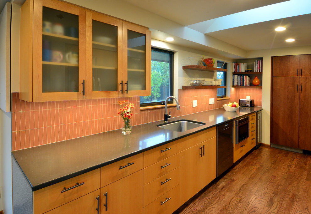 Eat-in kitchen - mid-sized 1950s galley medium tone wood floor eat-in kitchen idea in Seattle with a drop-in sink, flat-panel cabinets, medium tone wood cabinets, quartz countertops, orange backsplash, glass tile backsplash, stainless steel appliances and brown countertops
