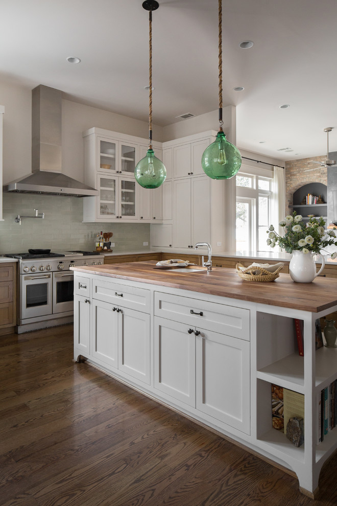 This is an example of a classic kitchen in Houston with shaker cabinets, green splashback, ceramic splashback, stainless steel appliances, an island, white cabinets, wood worktops, dark hardwood flooring, brown floors and brown worktops.